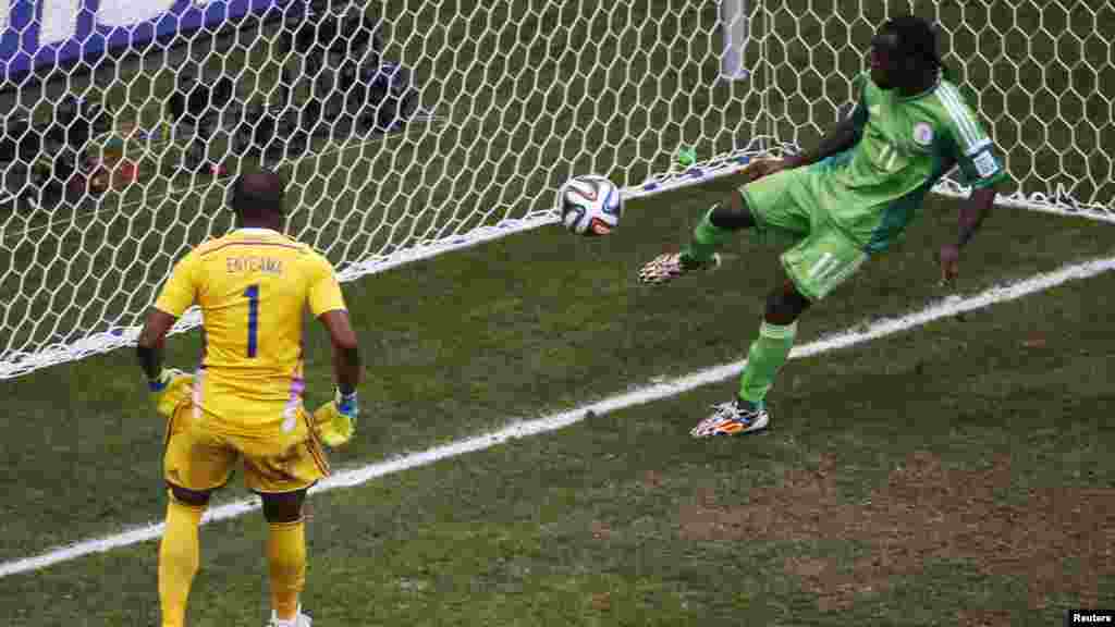 Le Nigérian Victor Moses sauve le tir du Français Karim Benzema, lors d&#39;un match entre le Nigeria et la France, Brasilia, le 30 juin 2014.