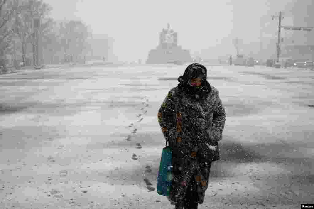 A woman makes her way through heavy snow fall at Gyeongbok palace in central Seoul, South Korea.