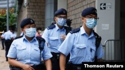 Police stand guards as a prison van arrive High Court on the first day of trial of Tong Ying-kit, the first person charged under a new national security law, in Hong Kong, June 23, 2021.
