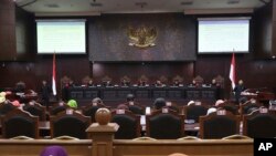 FILE - Judges read their verdict on the case of a petition seeking to make gay sex and sex outside marriage illegal during a hearing at the Constitutional Court in Jakarta, Indonesia, Thursday, Dec. 14, 2017.