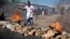 A civilian jumps over a burning barricade of rocks erected by residents to protect themselves from police, in a northern district of the capital Bujumbura, in Burundi, May 14, 2015. 