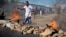 A civilian jumps over a burning barricade of rocks erected by residents to protect themselves from police, in a northern district of the capital Bujumbura, in Burundi, May 14, 2015. 