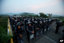 Kordon policajaca u opremi za razbijanje demonstracija blokira put kako bi zaustavio karavan hiljada centralnoameričkih migranata da dalje prođu ka gradu Ariega, Čiapas, meksiko, 27. oktobra 2018.