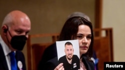 Belarusian opposition leader Sviatlana Tsikhanouskaya shows a photograph as she speaks at Czech Senate in Prague, Czech Republic, June 9, 2021. 