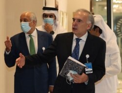 US special envoy for Afghanistan Zalmay Khalilzad (L) and the United Nations Secretary-General's personal envoy on Afghanistan Jean Arnault walk down a hotel lobby in Doha during an international meeting, Aug. 10, 2021.