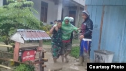 Personel TNI membantu evakuasi seorang warga desa Lengkeka, Kabupaten Poso, Sulawesi Tengah pasca peristiwa banjir bandan, 3 Maret 2020. (Foto : Twitter/@Agus Wibowo) 