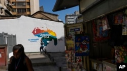 Locals walk past a mural of the Venezuelan map with the Essequibo territory included, in Caracas, Venezuela, on November 29, 2023. (Matias Delacroix/AP)
