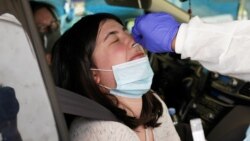 Seorang penumpang menerima tes swab pada drive-through di Leesburg, AS