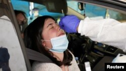 អ្នក​ដំណើរ​ម្នាក់​បើក​ឡាន​ចូល​ទៅ​ធ្វើ​តេស្ត​នៅ​កន្លែង​ធ្វើ​តេស្ត​មួយ​កន្លែង​ក្នុង​ក្រុង Leesburg រដ្ឋ Virginia សហរដ្ឋអាមេរិក ដើម្បី​រក​ជំងឺ​កូវីដ១៩ កាល​ពី​ថ្ងៃ​ទី​២០ ខែឧសភា ឆ្នាំ​២០២០។ 