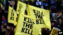 Demonstrators hold flags during a 'Kill the Bill' protest in London, April 3, 2021. The demonstration is against the contentious Police, Crime, Sentencing and Courts Bill, which is currently going through Parliament.