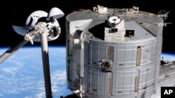 In this image from NASA TV, the SpaceX Crew Dragon capsule, left, approaches the International Space Station, April 24, 2021. 