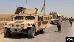 FILE - Afghan National Army troops arrive in the Nad Ali district of southern Helmand province, Aug. 10, 2016. An overnight airstrike in the area reportedly has killed at least 24.