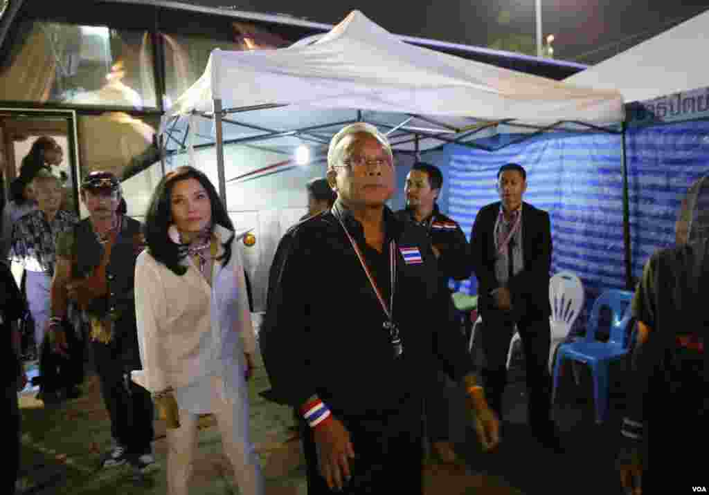 Anti-government protest leader Suthep Thaugsuban, center, with his wife Srisakul Promphan, in white, arrives at the Democracy monument, in Bangkok, Thailand, Dec. 15, 2013.&nbsp;