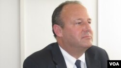 People walk through the gate of the Sachsenhausen Nazi death camp with the phrase &#39;Arbeit macht frei&#39; (work sets you free) at the eve of the International Holocaust Remembrance Day, in Oranienburg, about 30 kilometers, (18 miles) north of Berlin, Jan. 26, 2015.