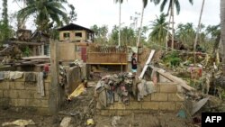 A resident stands inside a destroyed house in Loboc town, Bohol province, Philippines, days after super Typhoon Rai devastated the province. 