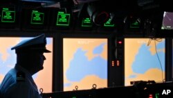 FILE - A U.S. Navy officer stands on the weapons control deck of the USS Monterey as screens display the Black Sea region, in the Black Sea port of Constanta, Romania, June 7, 2011. NATO activated an $800 million missile defense site in southern Romania on May 12, 2016.