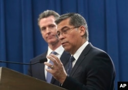 FILE - California Attorney General Xavier Becerra (R), accompanied by Gov. Gavin Newsom, announce their intent to sue the Trump administration over an emergency declaration to fund a border wall, Feb. 15, 2019, in Sacramento, California.