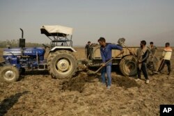 Kashmiri villagers collect soil from a dried portion of Wular Lake, northeast of Srinagar, Indian-controlled Kashmir, Oct. 29, 2016. Wular Lake holds less than half its former capacity, and restoring it may prove too tough.
