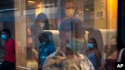 Para penumpang kereta api mengenakan masker di stasiun kereta utama di Barcelona, Spanyol, 28 Agustus 2020. (Foto: AP)