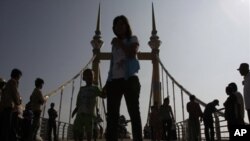 Cambodians walk on a bridge (now removed) on which hundreds of people stampeded during a water festival on Nov. 22, 2010.
