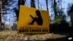 A sign that reads "our children deserve better safe choice now" is seen on Friday, Jan. 15, 2021, in Decatur, Ga., just down the road from the U.S. Centers for Disease Control and Prevention. (AP Photo/Brynn Anderson)