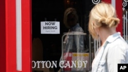 FILE - A "Now Hiring" sign is posted in the window of The Wharf Chocolate Factory, at Fisherman's Wharf, in Monterey, California, Aug. 6, 2021.