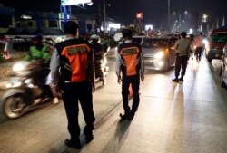 Para petugas Dishub dan polisi menjaga pos pemeriksaan di Cibitung, Bekasi, Jawa Barat, saat penerapan larangan mudik nasional untuk mencegah penyebaran pandemi COVID-19, Minggu, 9 Mei 2021. (Foto: Achmad Ibrahim/AP)