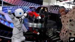 In this April 26, 2018, photo, a robot entertains visitors at the booth of a Chinese automaker during the China Auto 2018 show in Beijing, China. (AP Photo/Ng Han Guan)