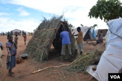 Refugees erecting new shelters at Kapise II camp. (Lameck Masina/VOA)
