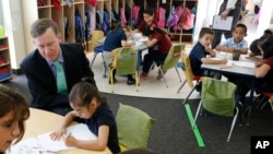 Colorado Gov. John Hickenlooper visits with young students in a third grade classroom at McGlone Elementary School, in the Montbello section of Denver, Thursday May 14, 2015.(AP Photo/Brennan Linsley)