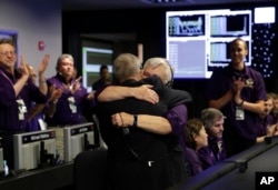 Project manager Earl Maize, center left, and flight director Julie Webster hug in mission control at NASA's Jet Propulsion Laboratory, Sept. 15, 2017, in Pasadena, Calif., after confirmation of Cassini's demise.