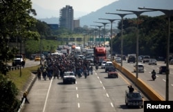 People walk in a caravan of migrants departing from El Salvador en route to the United States, in San Salvador, El Salvador, Oct. 31, 2018.