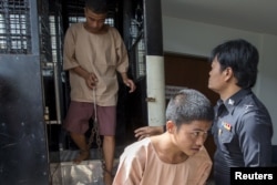 FILE - Myanmar migrant workers Zaw Lin, center and Wai Phyo, left, also known as Win Zaw Htun, arrive at the Koh Samui Provincial Court, in Koh Samui, Thailand, July 8, 2015.