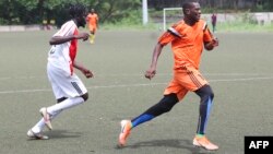 Chicco Sassou (à droite), 32 ans, s'exécute sur le terrain de football de Libreville le 4 mars 2021.