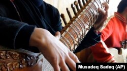 FILE - In this Jan. 7, 2013 file photo, an Afghan girl practices playing the sitar in a class at the Afghan National Institute of Music, ANIM, in Kabul, Afghanistan. 