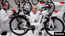 Pierre Forte (R), founder and CEO of Pragma Industries, and Alexandre Blanc (L), operations director, check an Alpha bike, first industrialized bicycle to use a hydrogen fuel cell at the Pragma Industries factory in Biarritz, France, Jan. 15, 2018. 