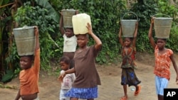 FILE - Children accused of witchcraft carrying water at the Children's Rights and Rehabilitation Network in Eket, Nigeria.