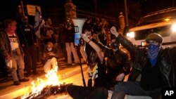 Para pengunjuk rasa meneriakkan slogan-slogan dan memblokir jalan dalam demo menuntut pengunduran diri Perdana Menteri Benjamin Netanyahu. Demo berlangsung di dekat kediaman resminya di Yerusalem, di tengah lockdown pandemi Covid-19, Sabtu, 2 Januari 2021.