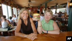 Ikki tadbirkor ayol restoranida tortiladigan burgerni ko'z-ko'z qilmoqda