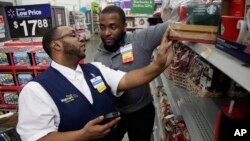 FILE - A Walmart employee, left, is coached by a trainer to use an inventory app at a Walmart store in North Bergen, New Jersey, Nov. 9, 2017. Nonfarm payrolls in the U.S. increased by 134,000 in September, according to a Labor Department report.