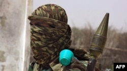 FILE - An Islamist fighter loyal to Somalia's al-Qaida-inspired al-Shabab group holds his arms during military drills in a village in the Lower Shabelle region, outside Mogadishu, Feb. 17, 2011.