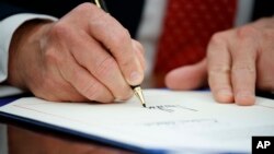 Presiden Donald Trump menandatangani executive order atau keputusan presiden, 28 Februari 2017 di Oval Office, Gedung Putih, Washington.