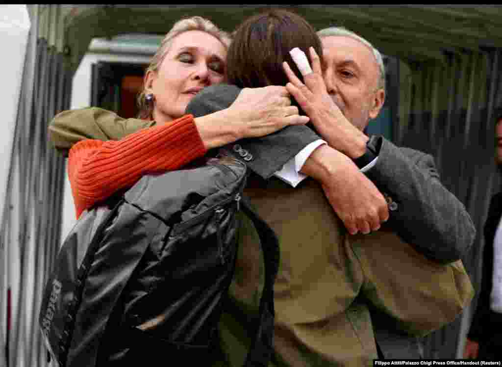 Italian journalist Cecilia Sala hugs her parents Elisabetta Vernoni and Renato Sala at Rome&#39;s Ciampino military airport after she was freed from detention in Iran.