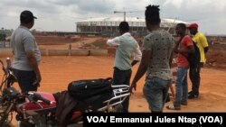 Des Camerounais observent l’etat d’avancement des travaux sur le site du stade d’Olembé. (VOA/ Jules Emmanuel Ntap)