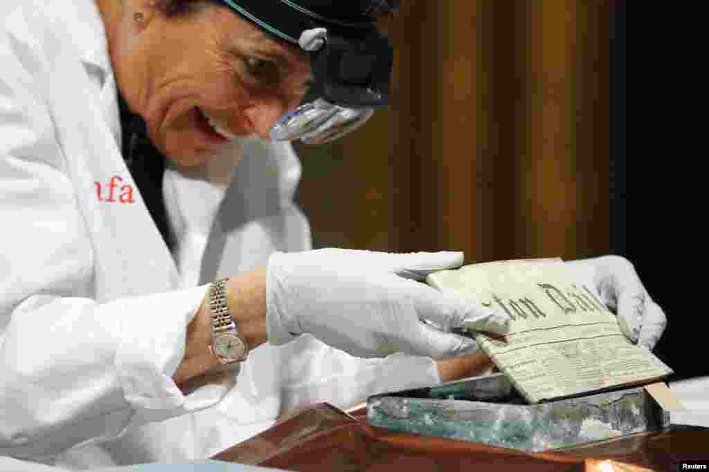 Conservator Pam Hatchfield removes a newspaper from a time capsule, which was placed under a cornerstone of the State House in 1795, at the Museum of Fine Arts, Boston, Massachusetts, Jan. 6, 2015. The capsule was placed by a group of the U.S. founding fathers including Samuel Adams, then the state&#39;s governor, and patriot Paul Revere.