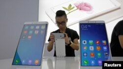 FILE - A journalist takes a picture of China's mobile company Xiaomi's new model Mi Max at its launching ceremony in Beijing, May 10, 2016. 