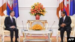 Cambodia's Prime Minister Hun Sen (R) speaks to China's Foreign Minister Wang Yi during a meeting at the Peace Palace in Phnom Penh on October 12, 2020.