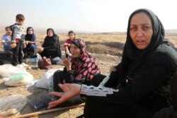 Displaced Kurds stuck at a border after a Turkish offensive in northeastern Syria, wait to try cross to the Iraqi side, at the Semalka crossing, next Derik city, Syria, Oct. 21, 2019.