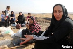 Displaced Kurds stuck at a border after a Turkish offensive in northeastern Syria, wait to try cross to the Iraqi side, at the Semalka crossing, next Derik city, Syria, Oct. 21, 2019.