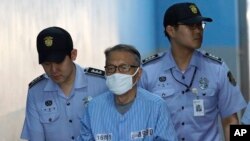 Former presidential chief of staff Kim Ki-choon, center, arrives at Seoul Central District Court in Seoul, South Korea, July 27, 2017.